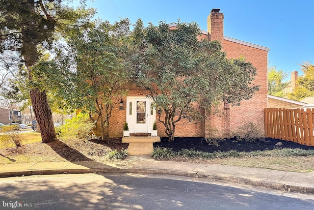 obstructed view of property with fence and a chimney