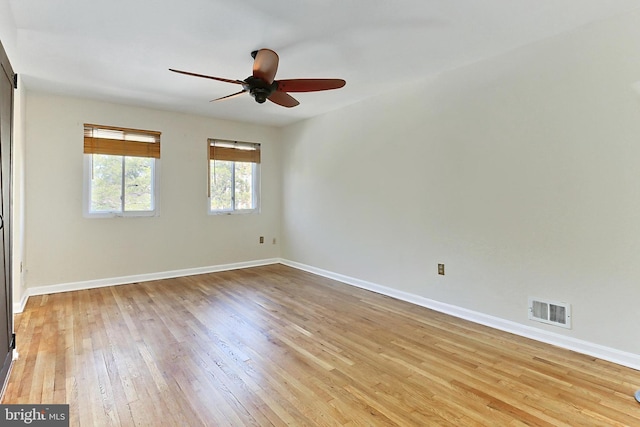 spare room featuring light wood-style flooring, baseboards, and visible vents