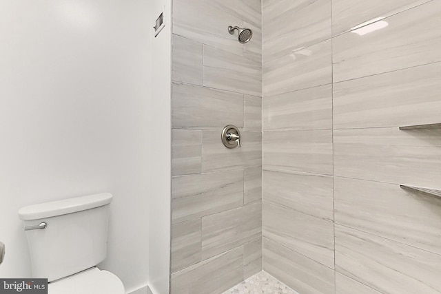 bathroom featuring toilet and tiled shower