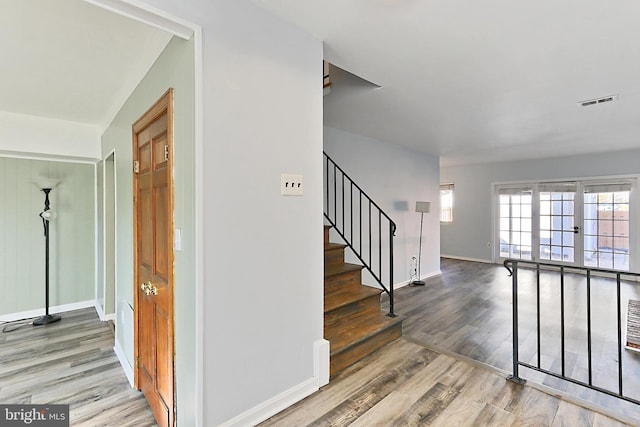 staircase featuring visible vents, baseboards, and wood finished floors