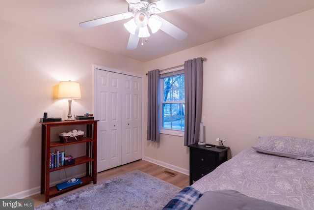 bedroom featuring baseboards, visible vents, ceiling fan, light wood-style floors, and a closet