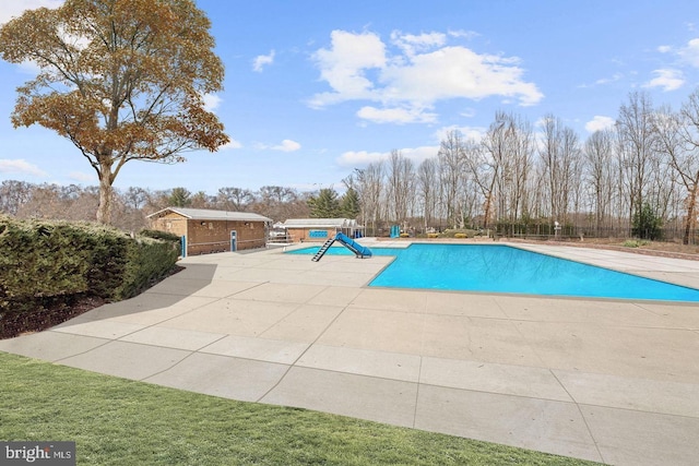 pool featuring a patio area and an outdoor structure