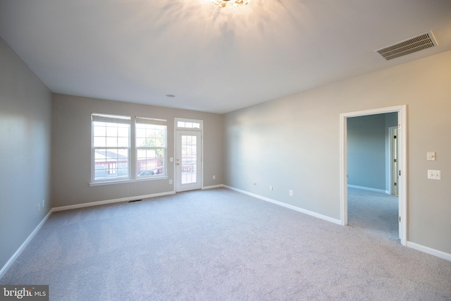 carpeted empty room featuring visible vents and baseboards