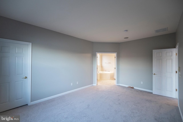 unfurnished bedroom featuring ensuite bath, carpet, baseboards, and visible vents