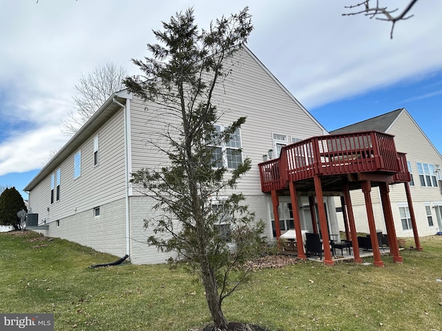 back of property featuring a yard, a patio, and a wooden deck