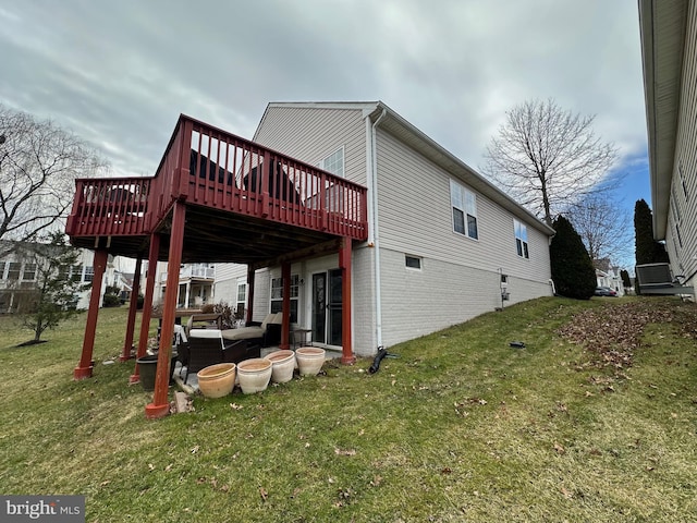 back of property with a yard and a wooden deck