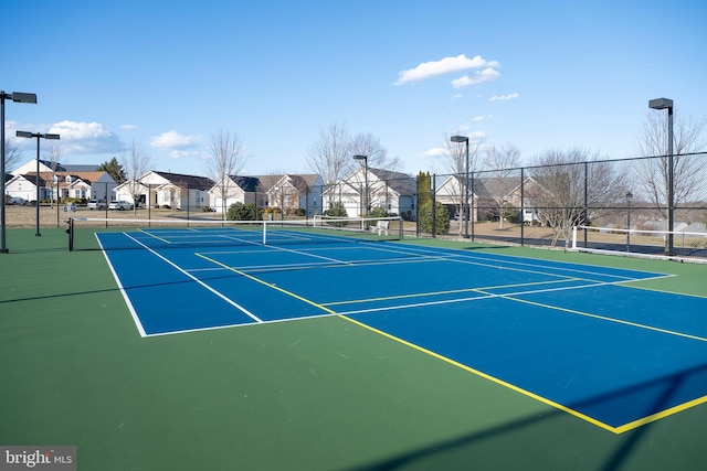 view of sport court with fence and a residential view