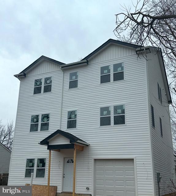 view of front facade with board and batten siding and an attached garage