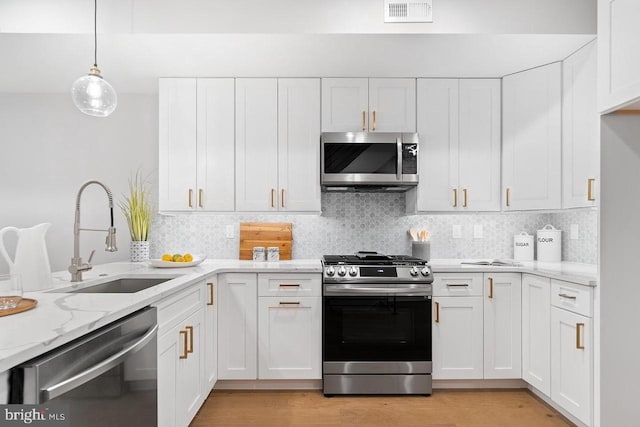 kitchen with white cabinets, visible vents, stainless steel appliances, and a sink