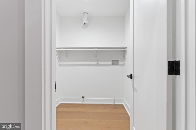 washroom featuring light wood finished floors, hookup for a washing machine, and baseboards