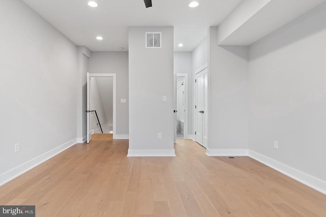 unfurnished room with recessed lighting, light wood-type flooring, visible vents, and baseboards