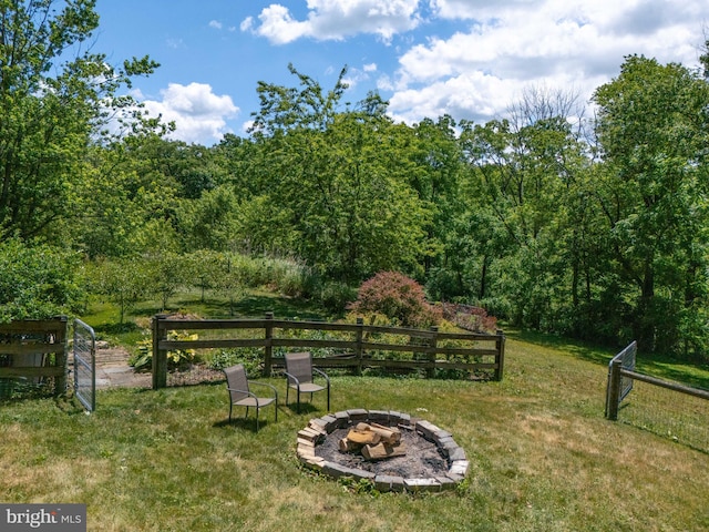 view of yard with an outdoor fire pit and fence