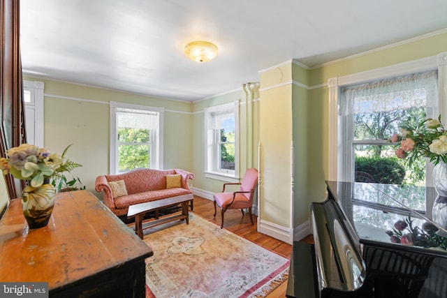 sitting room with crown molding, baseboards, and wood finished floors