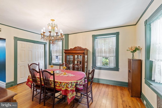 dining area featuring a notable chandelier, light wood finished floors, and baseboards