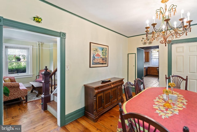 dining room featuring baseboards, stairway, and wood finished floors