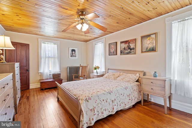 bedroom with wood ceiling, light wood finished floors, radiator heating unit, and baseboards