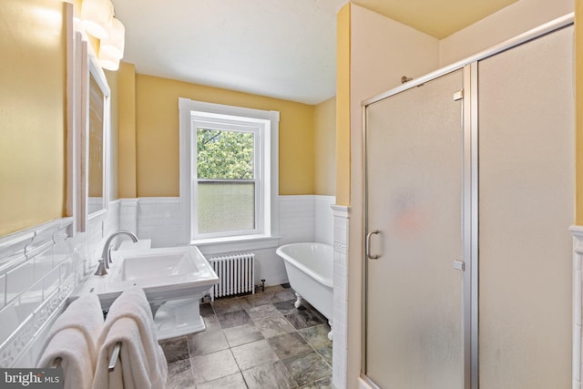 bathroom with a stall shower, wainscoting, a soaking tub, radiator heating unit, and tile walls