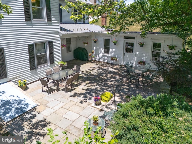 back of house with a patio area, metal roof, and outdoor dining area