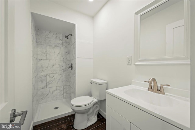 full bath with toilet, vanity, baseboards, wood tiled floor, and a stall shower