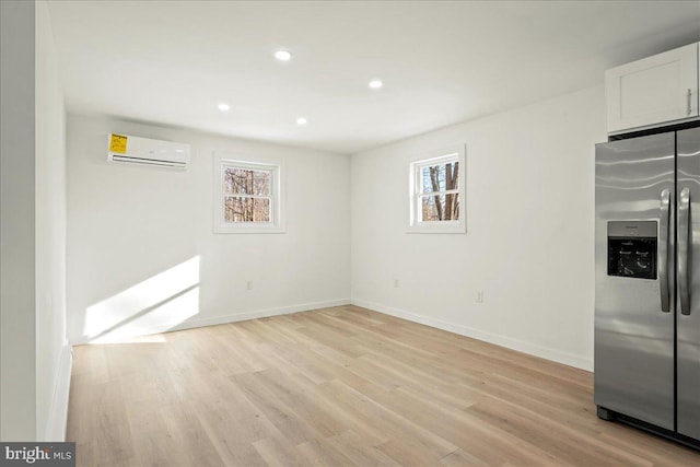 interior space featuring light wood-style floors, recessed lighting, baseboards, and a wall mounted AC