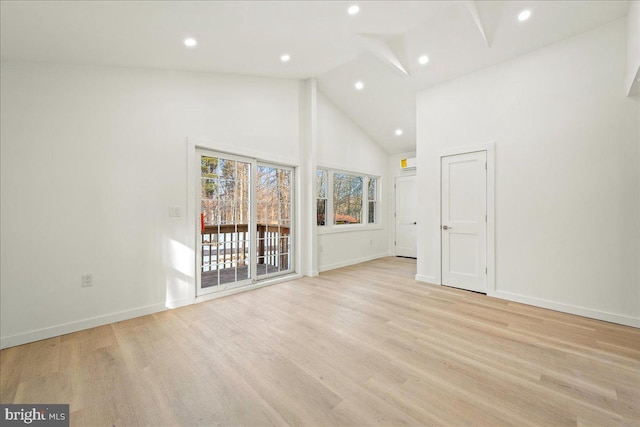 unfurnished room featuring high vaulted ceiling, recessed lighting, light wood-type flooring, and baseboards