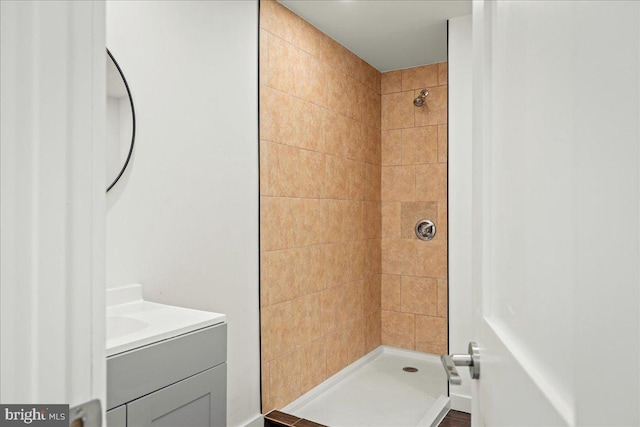 bathroom featuring a tile shower and vanity