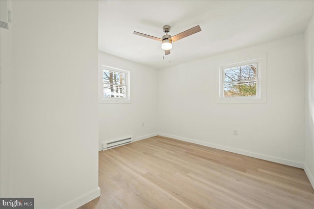 empty room featuring light wood-type flooring, baseboards, ceiling fan, and baseboard heating