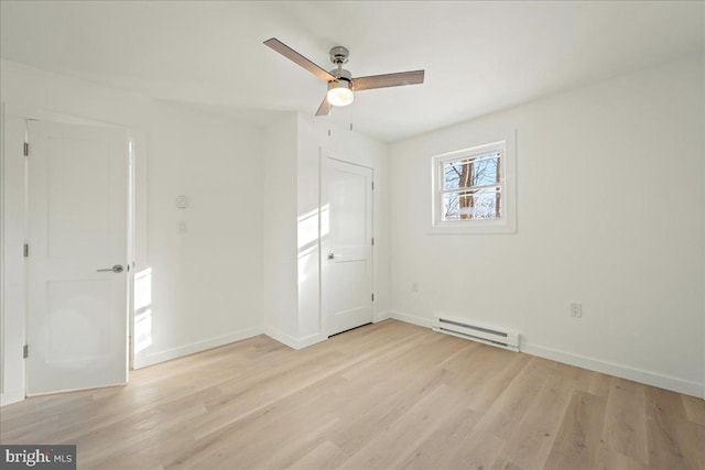 unfurnished bedroom with a ceiling fan, baseboard heating, light wood-style flooring, and baseboards