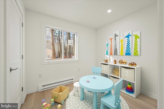 playroom featuring light wood-type flooring, baseboards, baseboard heating, and recessed lighting