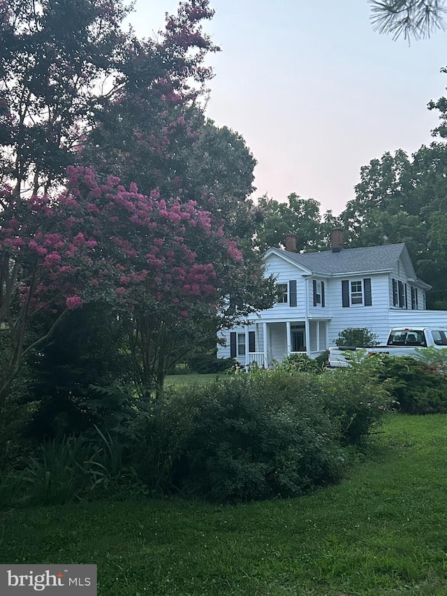 view of front of house with a front lawn and a chimney