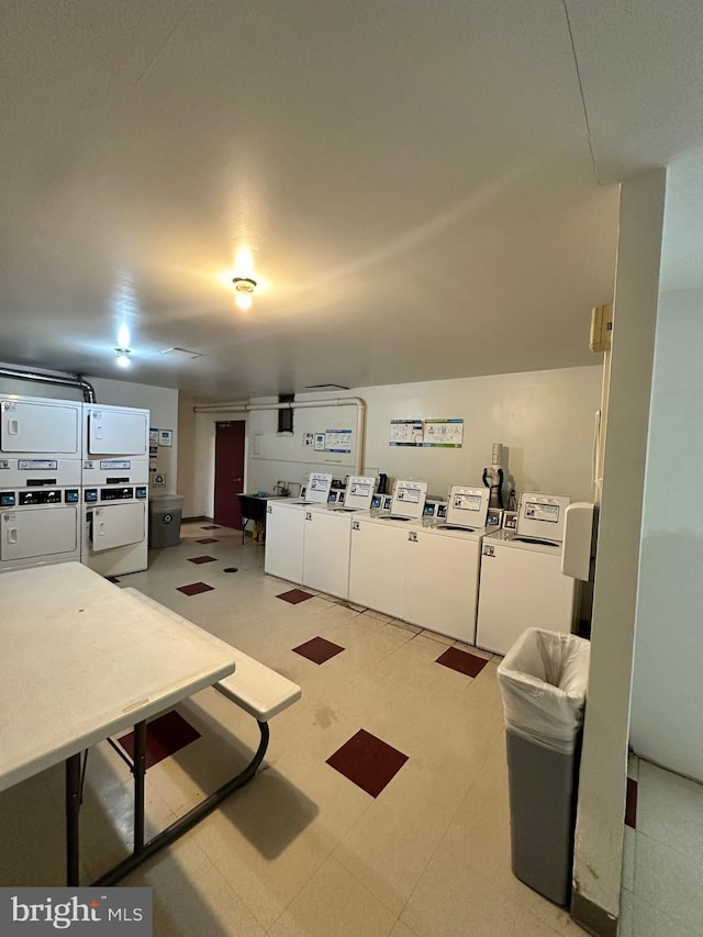 interior space with light floors, white cabinetry, washer and clothes dryer, and stacked washer / drying machine