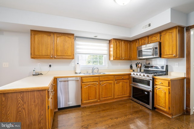 kitchen featuring a sink, visible vents, light countertops, appliances with stainless steel finishes, and brown cabinets