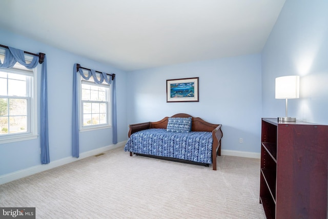 bedroom with visible vents, baseboards, and light colored carpet