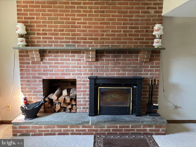 details featuring carpet floors, a brick fireplace, and baseboards