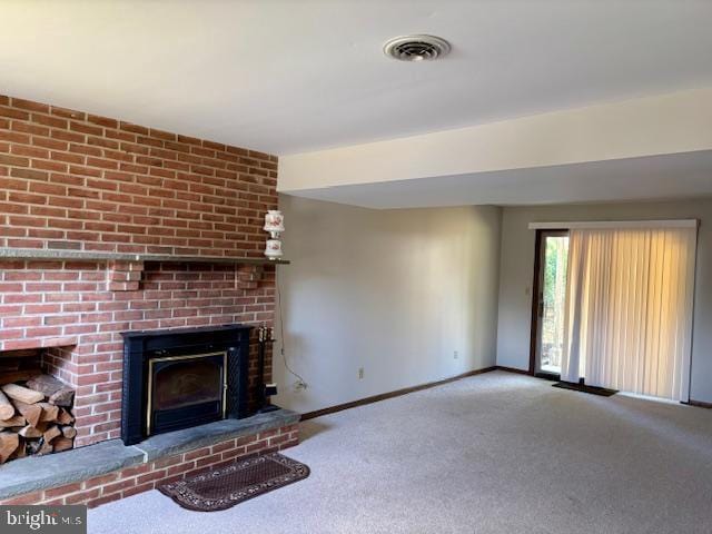 unfurnished living room with carpet floors, baseboards, a fireplace, and visible vents