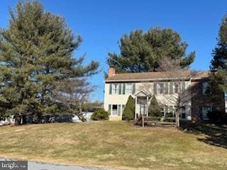 split foyer home featuring a front lawn and a chimney