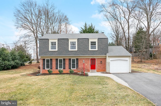 colonial inspired home featuring a gambrel roof, brick siding, driveway, and a shingled roof