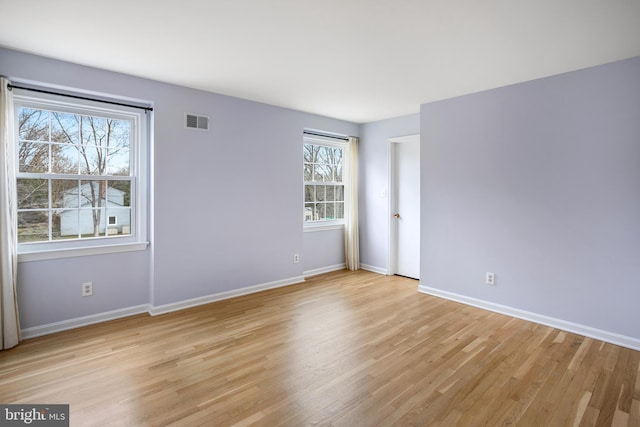 spare room featuring baseboards, visible vents, and light wood-type flooring