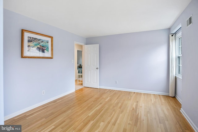 empty room with visible vents, baseboards, and light wood-style flooring