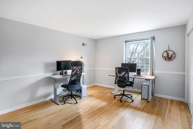 office with visible vents, baseboards, and wood finished floors