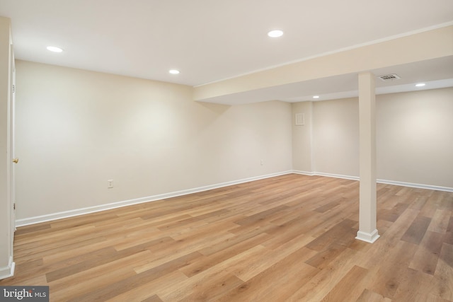 finished basement with light wood finished floors, visible vents, recessed lighting, and baseboards