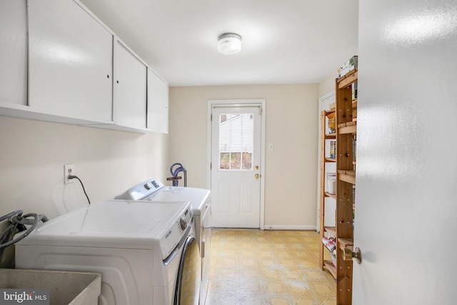 laundry room featuring separate washer and dryer, cabinet space, and light floors