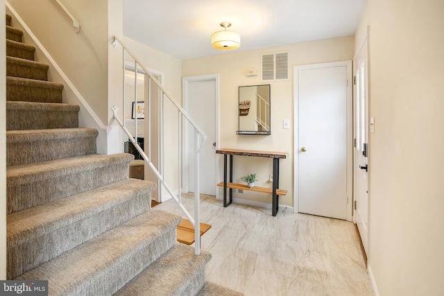 foyer entrance with stairs, baseboards, visible vents, and marble finish floor