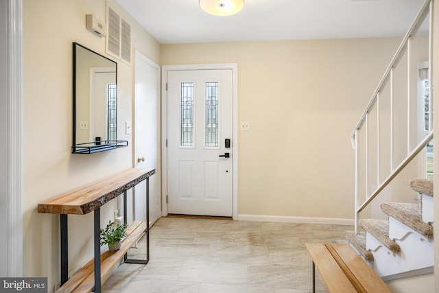 foyer with stairway, baseboards, and visible vents