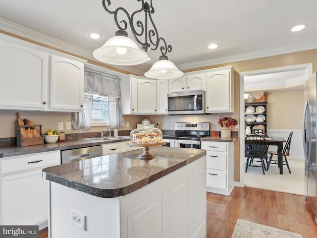 kitchen featuring stainless steel appliances, dark countertops, a kitchen island, and decorative light fixtures