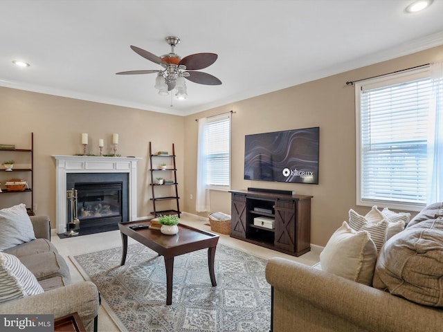 living area with ornamental molding, a ceiling fan, and light colored carpet