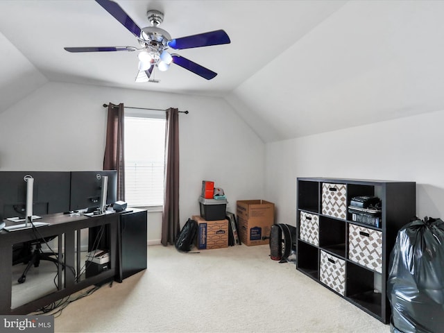 carpeted office space with vaulted ceiling and a ceiling fan