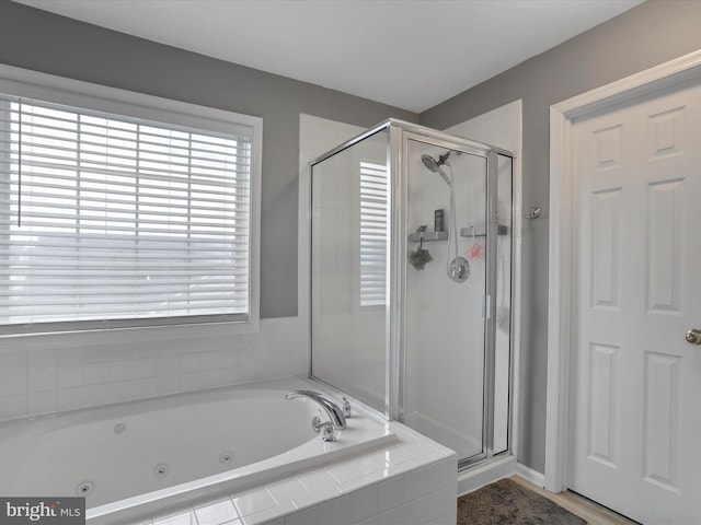 bathroom featuring a whirlpool tub and a shower stall