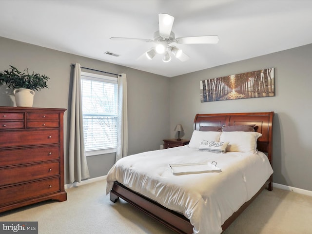 bedroom featuring light carpet, baseboards, visible vents, and a ceiling fan