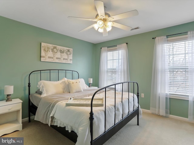 bedroom featuring baseboards, a ceiling fan, visible vents, and light colored carpet